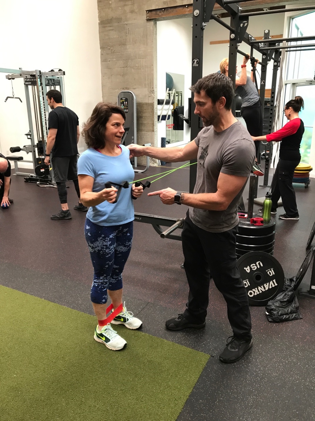 picture of trainer using ROCK Tape, and Picture of Trainer assisting client in range of motion exercise